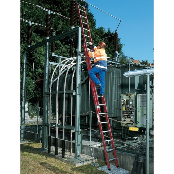 Eine Person steigt auf eine Anlegeleiter an einem Transformator.