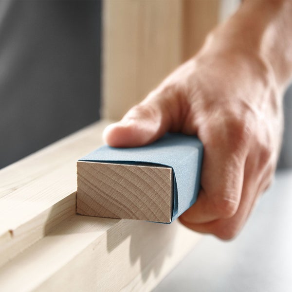 Hand schleift Holz mit Schleifpapier