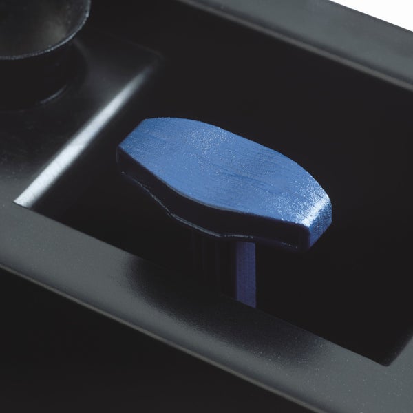 Nahaufnahme eines blauen Kunststoffgriffs an einem schwarzen Gehäuseteil.