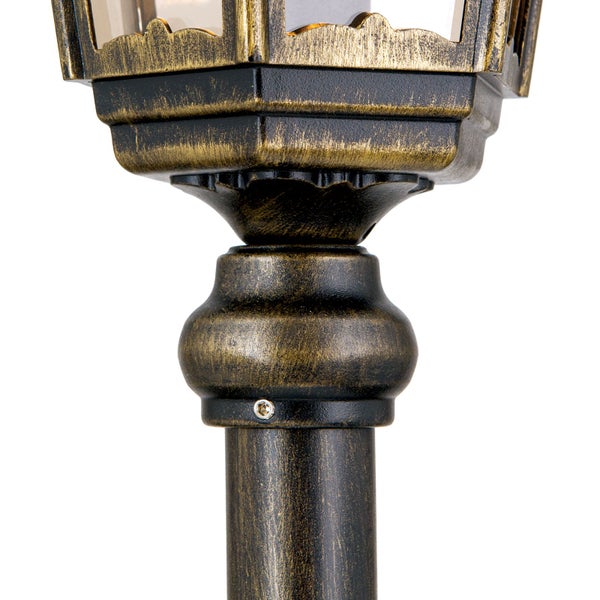Detail einer Außenlampe in Antik-Optik, schwarz-goldenes Metall mit dekorativem Sockel und Befestigungsschraube.