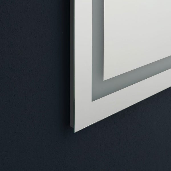 Nahaufnahme der Ecke eines Badezimmerspiegels mit integriertem LED-Lichtband und mattiertem Rand.