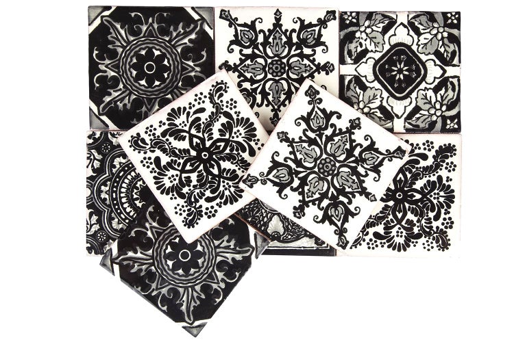 Mehrere quadratische Fliesen mit floralen Mustern in Schwarz-Weiss