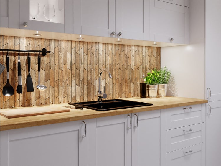 Moderne Küche mit einer Arbeitsplatte in Holzoptik, einer schwarzen Spüle mit verchromter Armatur und einer Küchenrückwand in Holzdekor.