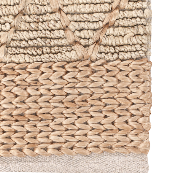 Detailansicht eines handgewebten Teppichs mit verschiedenen Strukturen aus Naturfasern wie Jute und Wolle.