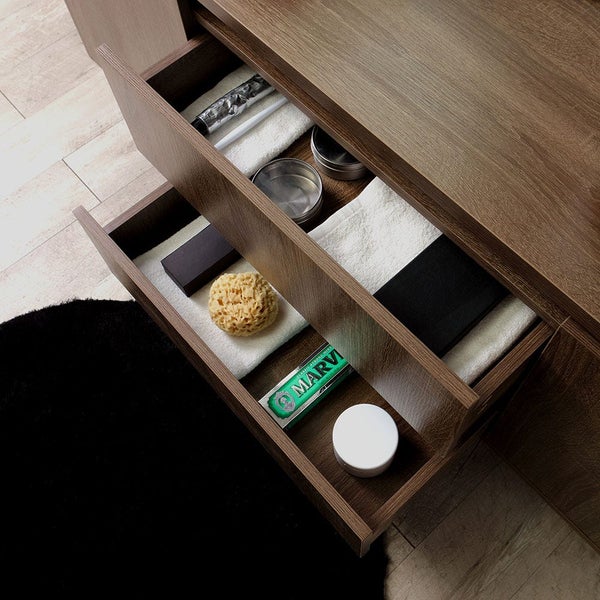 Badezimmerschrank mit offenen Schubladen, gefüllt mit Badaccessoires wie Schwamm, Seife, Handtüchern und Zahnpasta