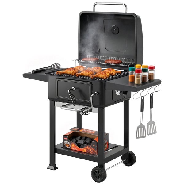 Schwarzer Holzkohle-Grillwagen mit offenem Deckel, Grillgut, Seitenablagen mit Gewürzen, Grillbesteck und Holzkohlebriketts im Untergestell.
