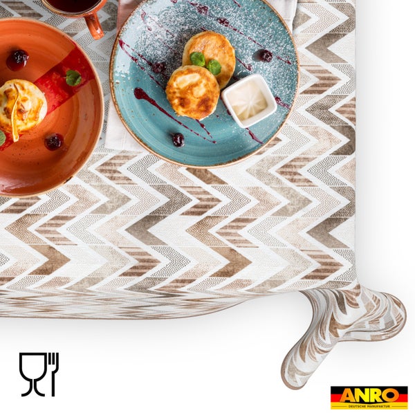 Abwaschbare Wachstischdecke mit Zickzack-Muster auf einem gedeckten Tisch, lebensmittelecht, ANRO Logo.