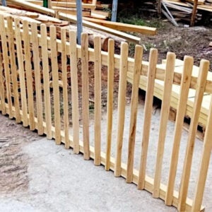 Lattenzaun aus Holz mit senkrechten Latten und abgerundeten Köpfen