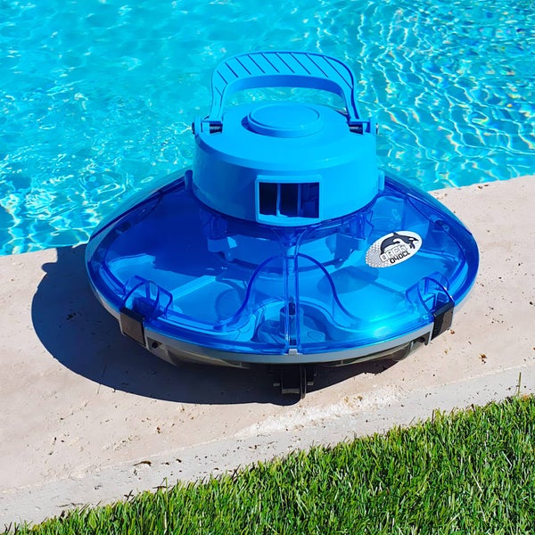 Blauer Poolroboter Orca 040CL am Rand eines Schwimmbeckens mit klarem Wasser und angrenzender Wiese.