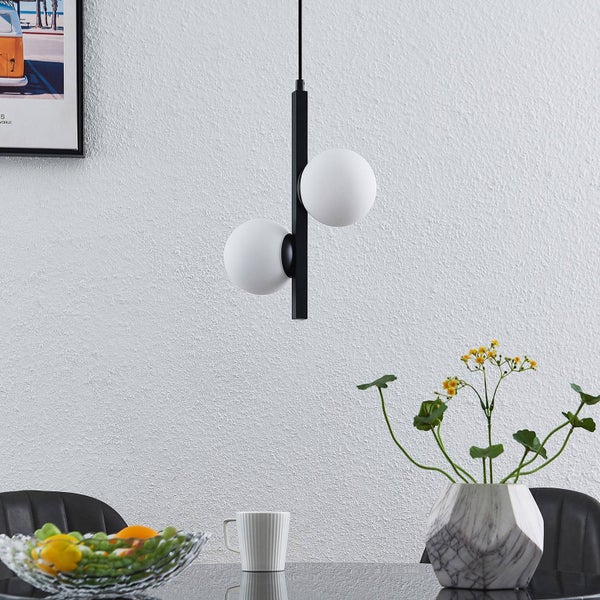 Moderne Pendelleuchte mit zwei runden Leuchtkörpern über einem Esstisch