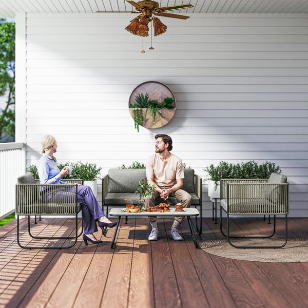 Terrassenszene mit Lounge-Sitzgruppe und zwei Personen auf einer Holzterrasse.