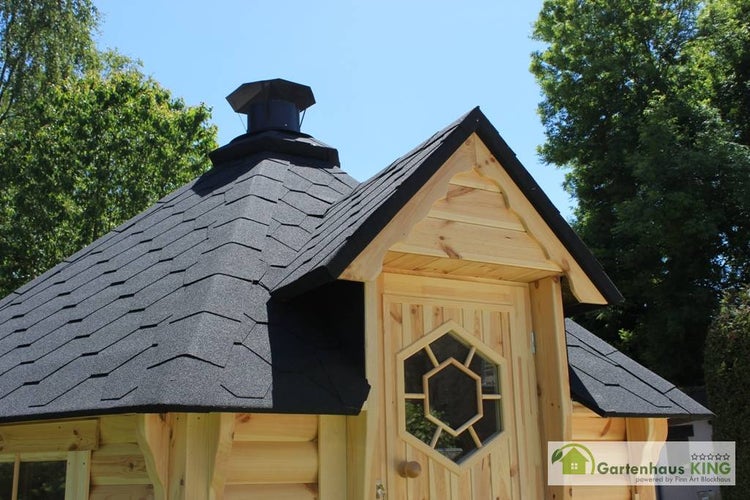 Detailansicht eines Gartenhauses mit Holztür und schwarzem Dach