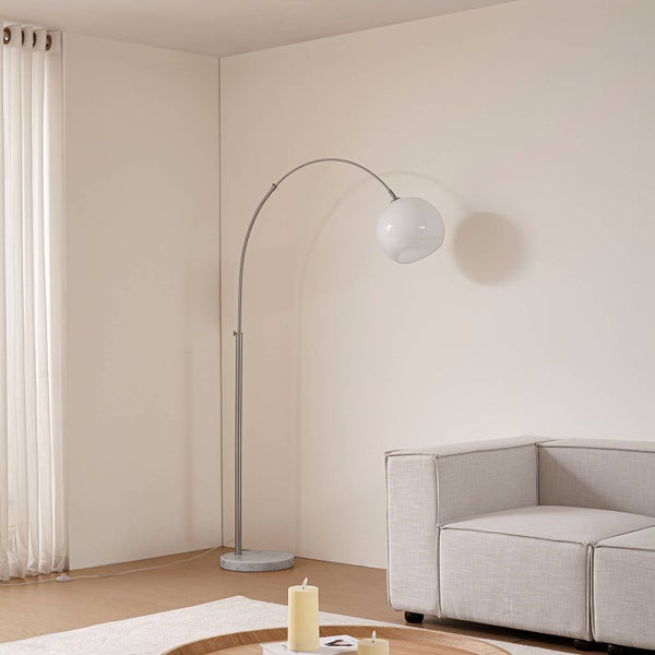 Stehleuchte mit gebogenem Metallgestell und runder Glaslampe in einem hellen Wohnraum