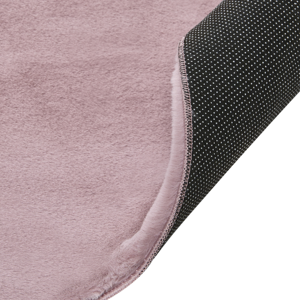 Weicher Kunstfellteppich in Rosa mit rutschfester Unterseite und geketteltem Rand.