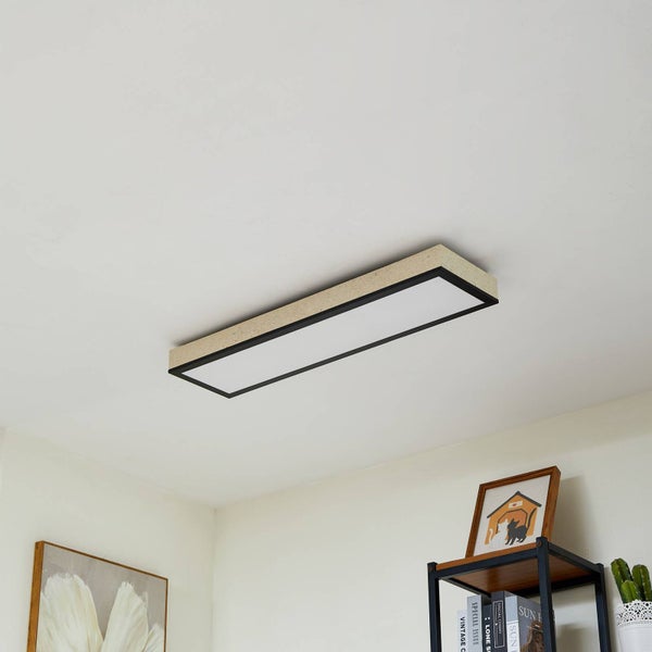 Moderne rechteckige LED-Deckenleuchte mit Rahmen in Steinoptik und schwarzem Rand in einem hellen, organisierten Raum mit Regal.