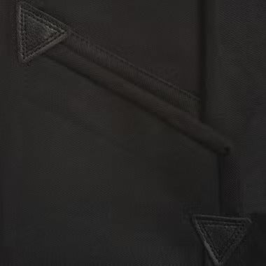 Detailaufnahme einer verstärkten Tasche an schwarzer Arbeitskleidung mit dreieckigen Verstärkungen und Nähten.