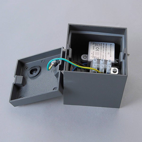 Offene LED-Wandleuchte mit Sicht auf den elektronischen Konverter, die Anschlussklemmen und die interne Verkabelung für die Montage.