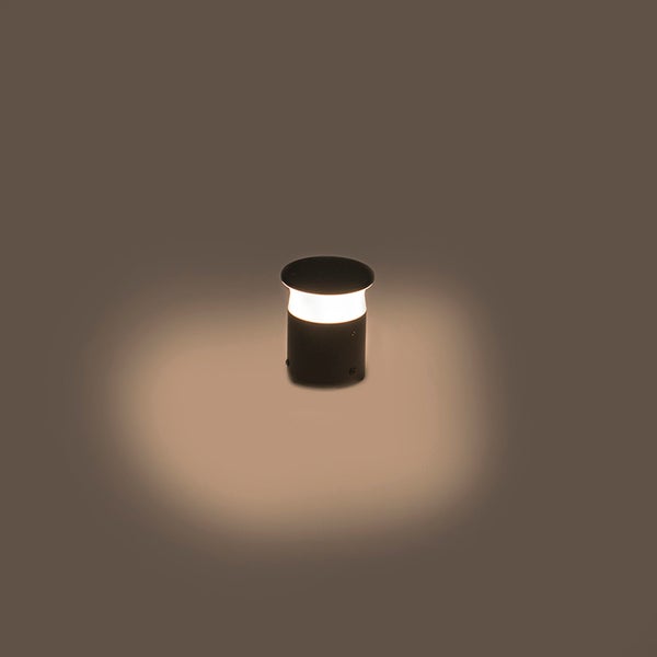 Beleuchtete schwarze zylindrische Außenleuchte als Wegeleuchte oder Sockelleuchte.