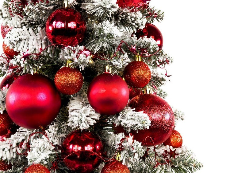 Weihnachtsbaum mit Kunstschnee dekoriert mit Weihnachtskugeln in verschiedenen Oberflächenbeschaffenheiten und Größen