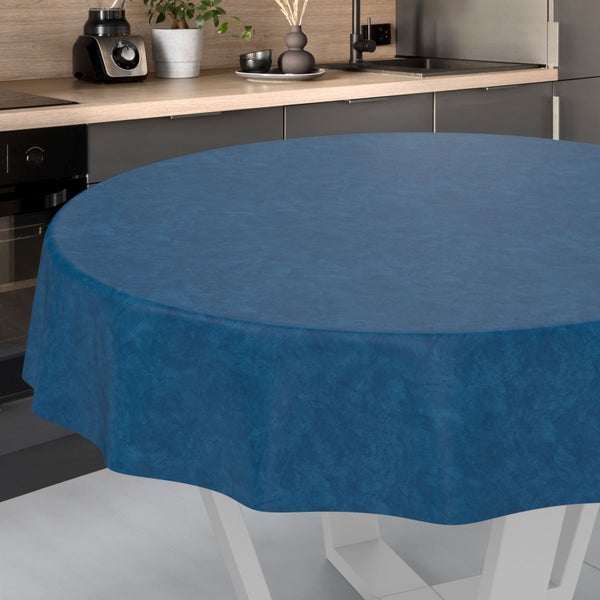 Runde, blau melierte Tischdecke auf einem runden Tisch in einer modern eingerichteten Küche.