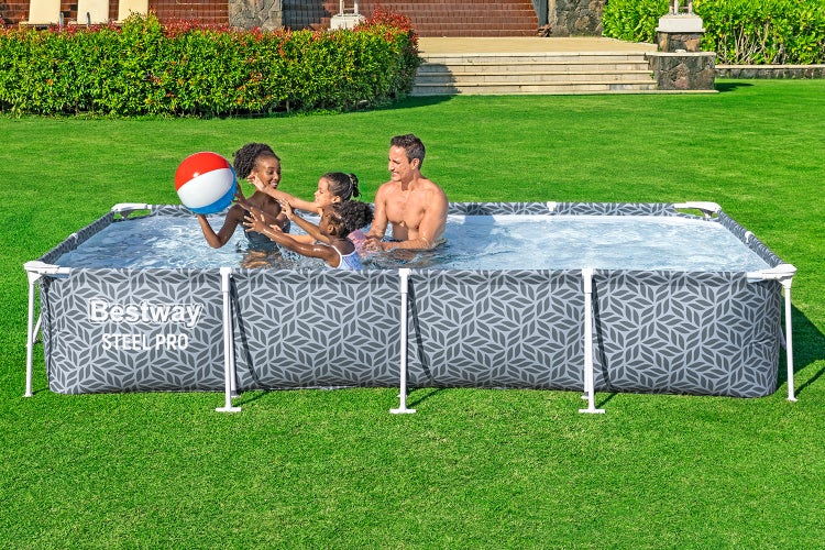 Bestway Steel Pro Framepool rechteckig mit Blattmuster auf einer Rasenfläche, eine Familie spielt im Wasser mit einem Wasserball.