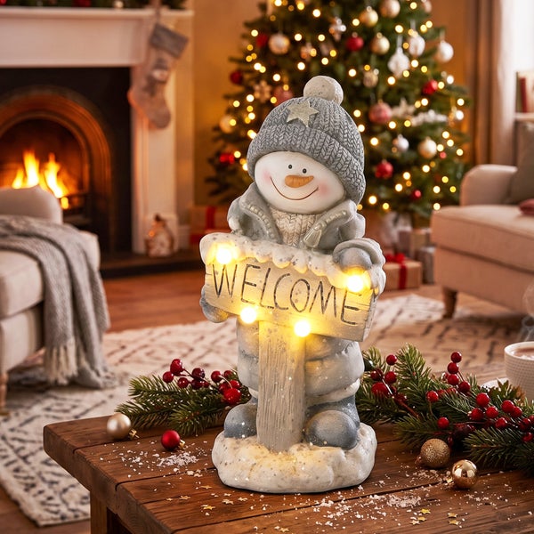 Weihnachtliche Schneemann Figur aus Kunststein mit beleuchtetem Willkommensschild und LED Beleuchtung als stimmungsvolle Weihnachtsdekoration.