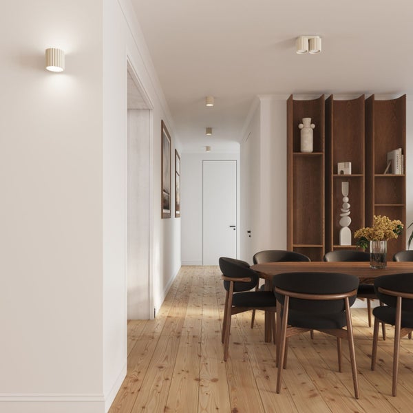 Modernes Esszimmer und Flur mit Holzfußboden, Esstisch aus Holz, Stühlen, großem Holzregal sowie geriffelten Wand- und Deckenleuchten.