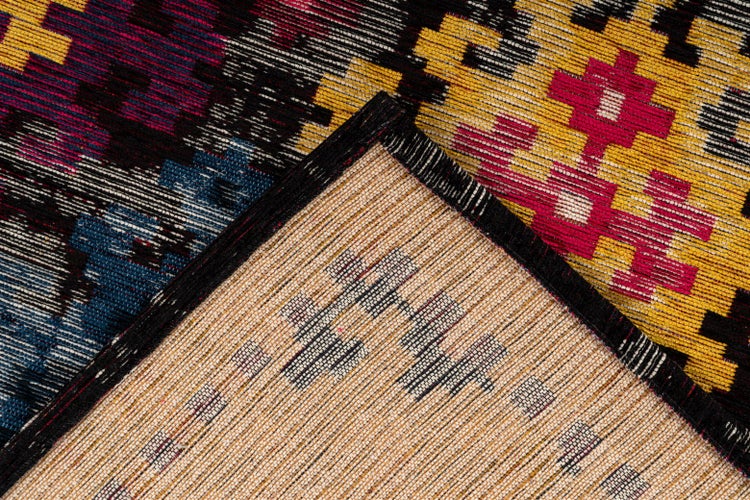 Nahaufnahme eines gewebten Teppichs mit geometrischem Muster, die Vorderseite, Rückseite und den Randabschluss zeigt.