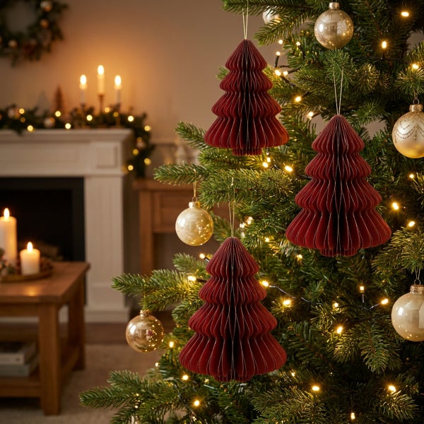Weihnachtsbaum mit Papierornamenten in Tannenbaumform, goldfarbenen Weihnachtskugeln und Lichterkette in einem wohnlichen Wohnzimmer.