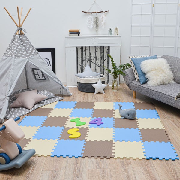 Helles Kinderzimmer mit einer bunten Puzzlematte aus Schaumstoff, einem Tipi-Zelt aus Stoff und einem Sofa auf hellem Holzboden.