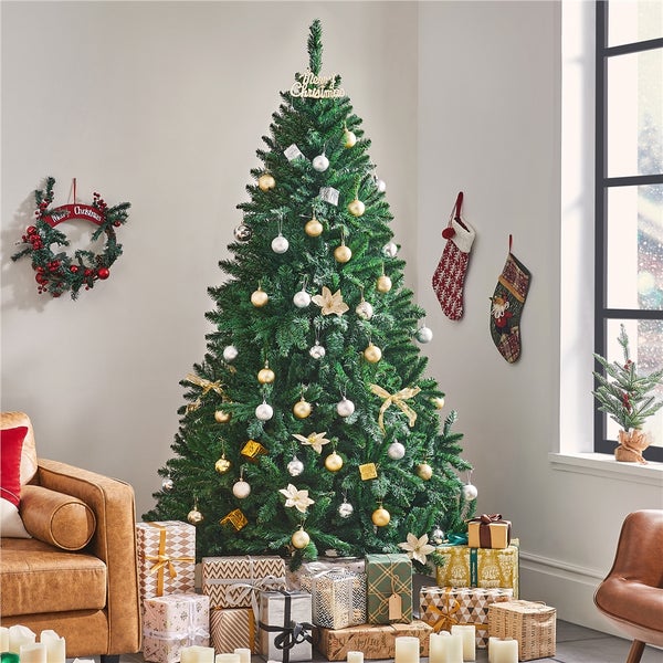 Geschmückter Weihnachtsbaum mit Geschenken und einem hölzernen Christbaumständer.