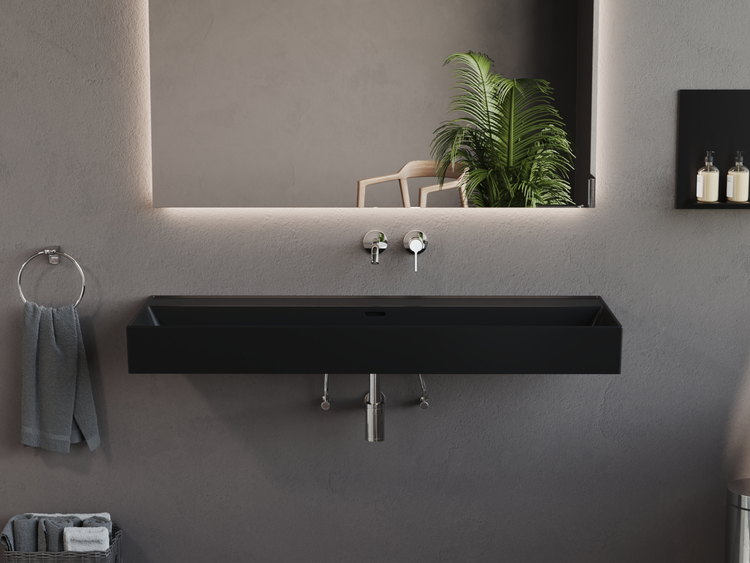 Modernes Badezimmer mit schwarzem Waschtisch, beleuchtetem Spiegel und Handtuchhalter.