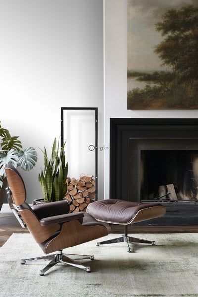 Wohnzimmer mit Ledersessel, Fußhocker, Kamin und Dekoration