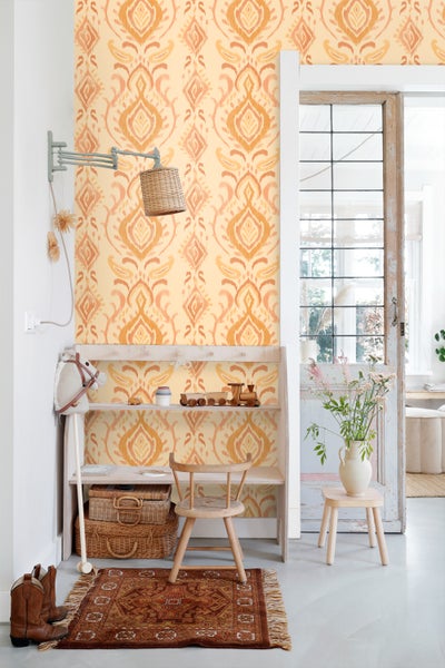Dekorative Wand mit gemusterter Tapete und Holzmöbeln in einem hellen Raum.