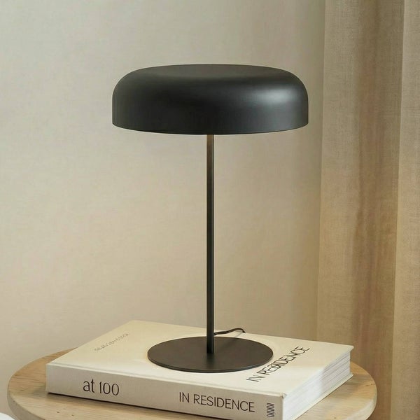 Schwarze Tischleuchte auf einem Buch