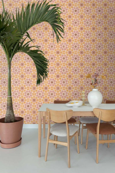 Geometrische Tapete mit Sternenmuster in einem hellen Esszimmer mit Holzmöbeln und einer Zimmerpalme.