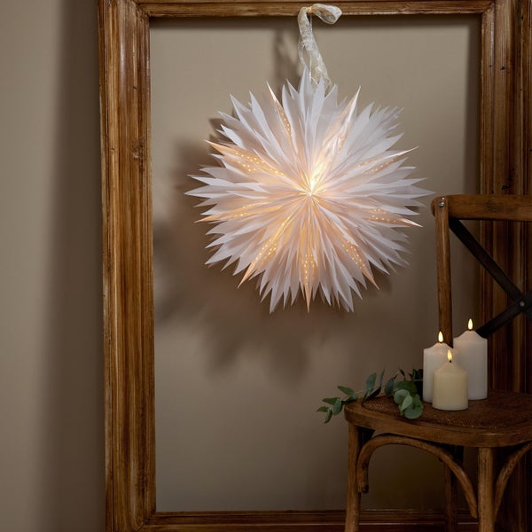 Dekorative Szene mit Papierstern, Kerzen und Holzrahmen