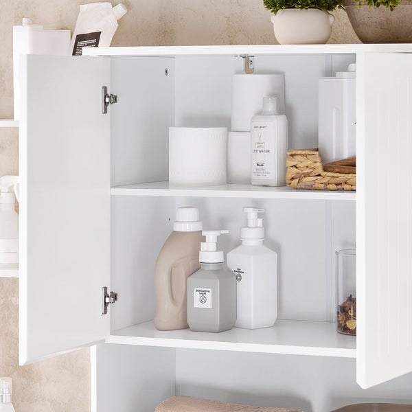 Badezimmerschrank mit offenen Türen und diversen Badartikeln wie Seife, Lotion und Papierhandtüchern