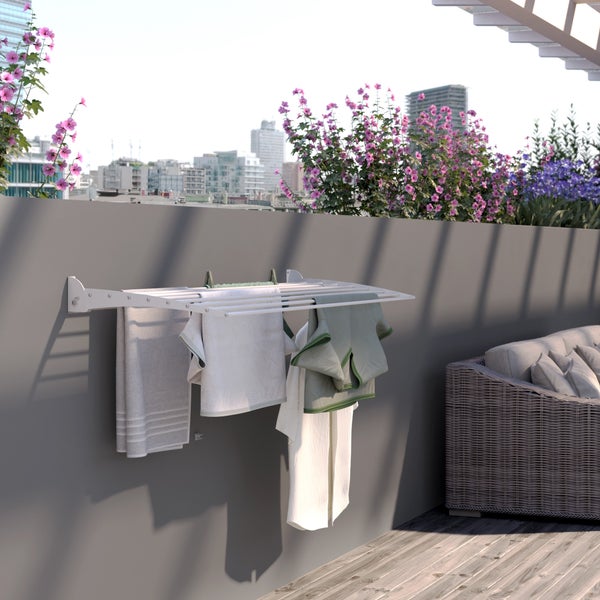 Wäscheständer zur Wandmontage mit Wäsche auf einem Balkon mit Stadtblick.