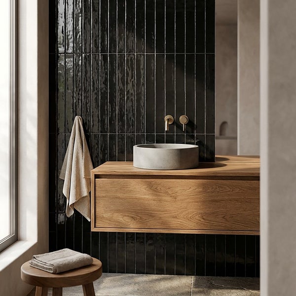Modernes Badezimmer mit Waschtisch aus Holz, rundem Aufsatzwaschbecken aus Beton und vertikalen glänzenden Wandfliesen.