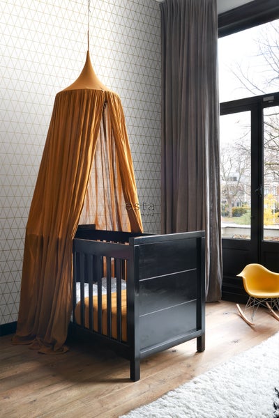 Kinderzimmer mit schwarzem Babybett und Baldachin