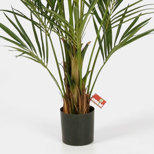 Künstliche Palme mit grünen Wedeln und strukturiertem Stamm in schwarzem Topf mit Tree Factory Logo.