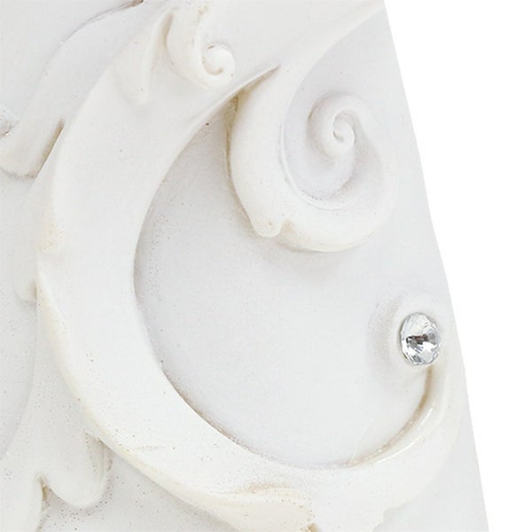 Vergrößerte Ansicht eines weißen Dekorationselements mit Ornamenten und Schmuckstein