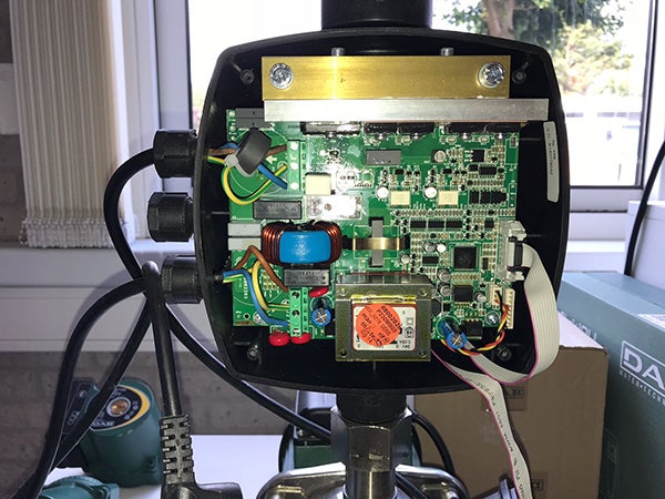 Innenansicht einer elektronischen Steuerung für eine Pumpe mit Platine, Kabeln und Bauteilen wie einem Transformator.
