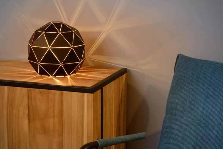 Dekorative Lampe auf einem Holzschrank neben einem Sessel