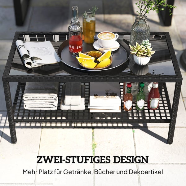 Zweistufiger Gartentisch aus Polyrattan mit Glasplatte, dekoriert mit Getränken, Büchern und Handtüchern auf einer Terrasse.