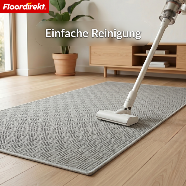 Floordirekt Logo. Ein Staubsauger reinigt einen gemusterten Teppich auf Holzboden in einem hellen, organisierten Raum. Einfache Reinigung.