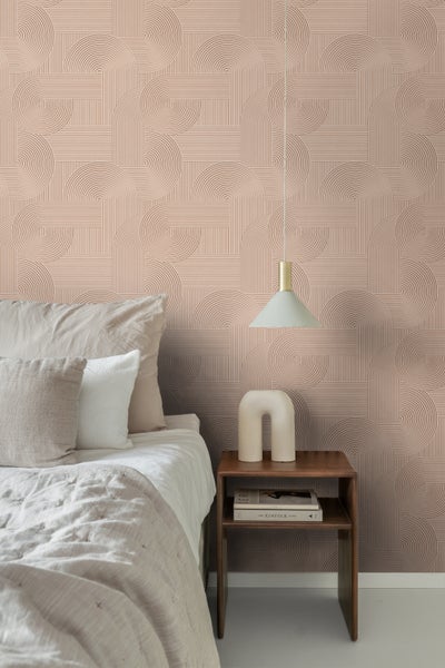 Vliestapete mit geometrischem Muster aus Linien und Kreisen in einem Schlafzimmer mit Bett und Nachttisch aus Holz.