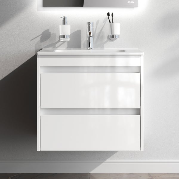 Weißer Waschtisch mit zwei Schubladen, Armatur, Seifenspender und Becher für Zahnbürsten.