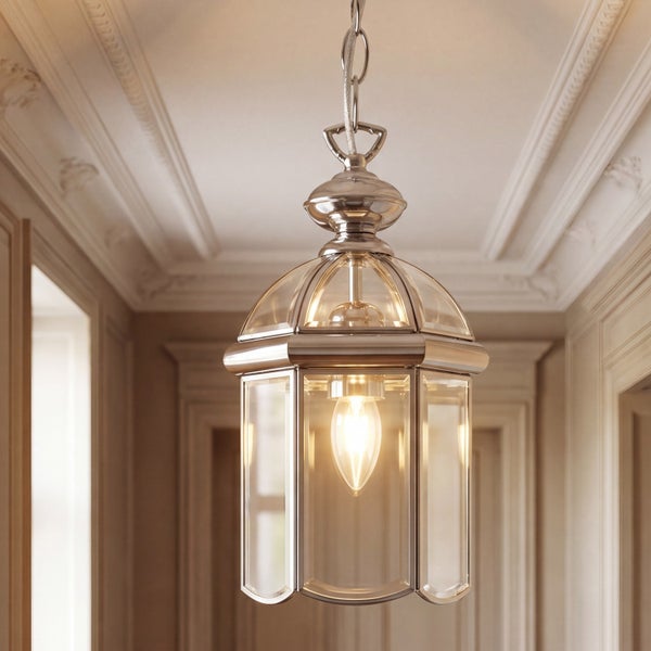 Pendelleuchte im Laternen-Stil aus Metall und klarem Glas in einem hellen Flur mit Deckenverzierungen.